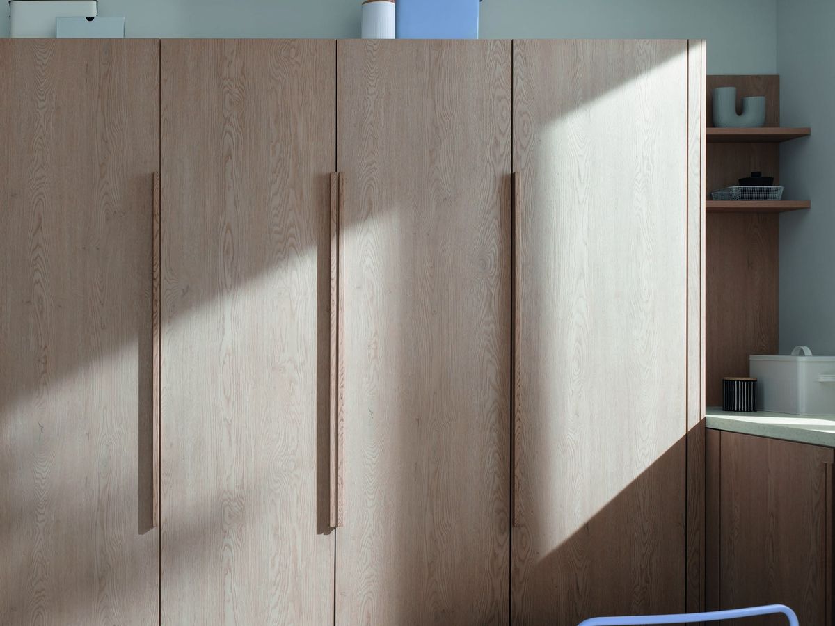 Lange houten grepen op een hoge kastenwand