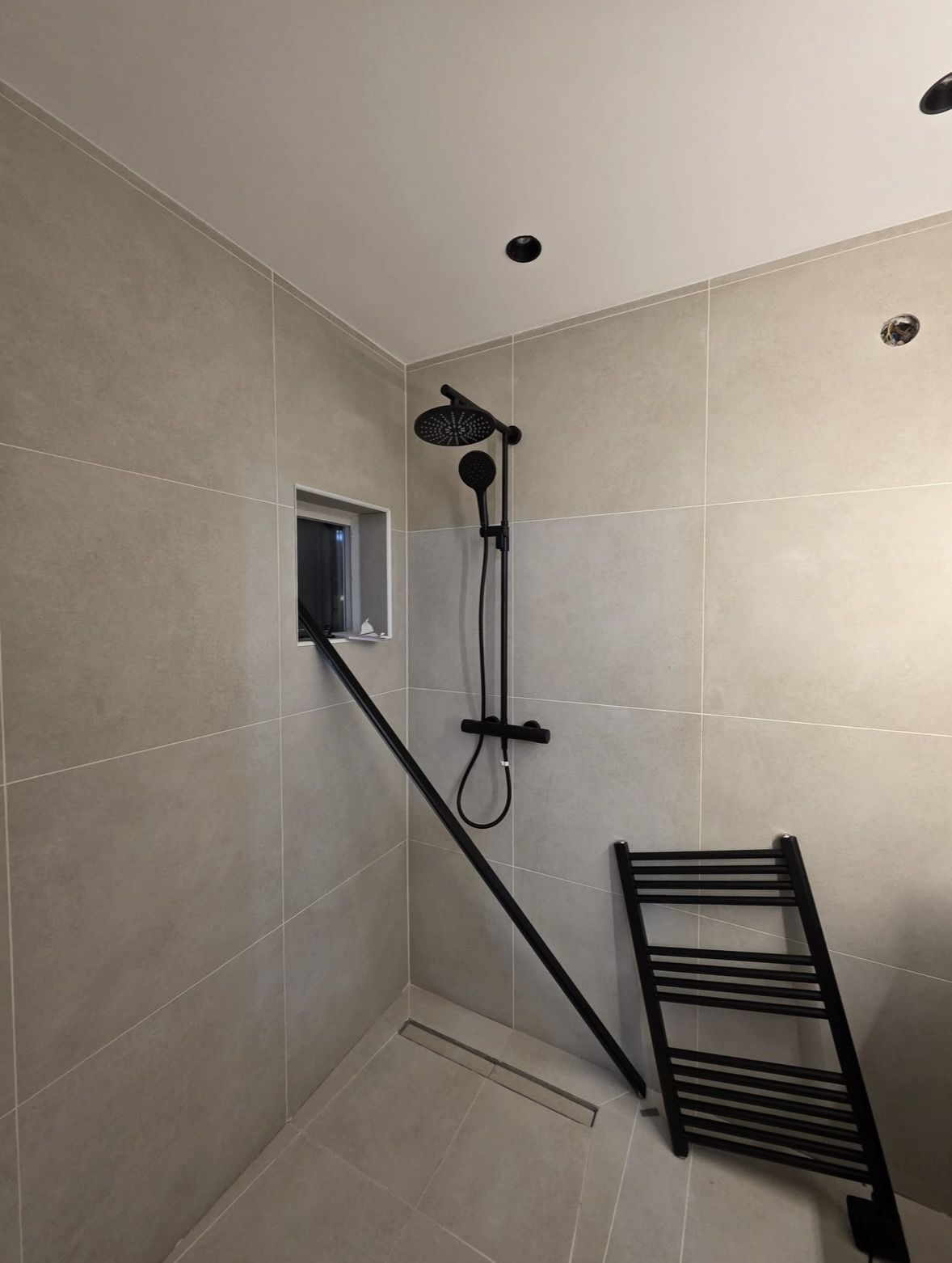 Renovatie woning Zaanstreek na oplevering: Regendouche, nis in de wand en douchegoot in de vloer