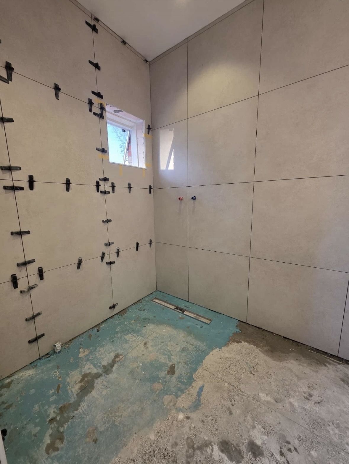 Renovatie woning Zaanstreek: Waterdichte laag op de vloer, douchegoot ingezet, tegels met nivelleerclips gesteld