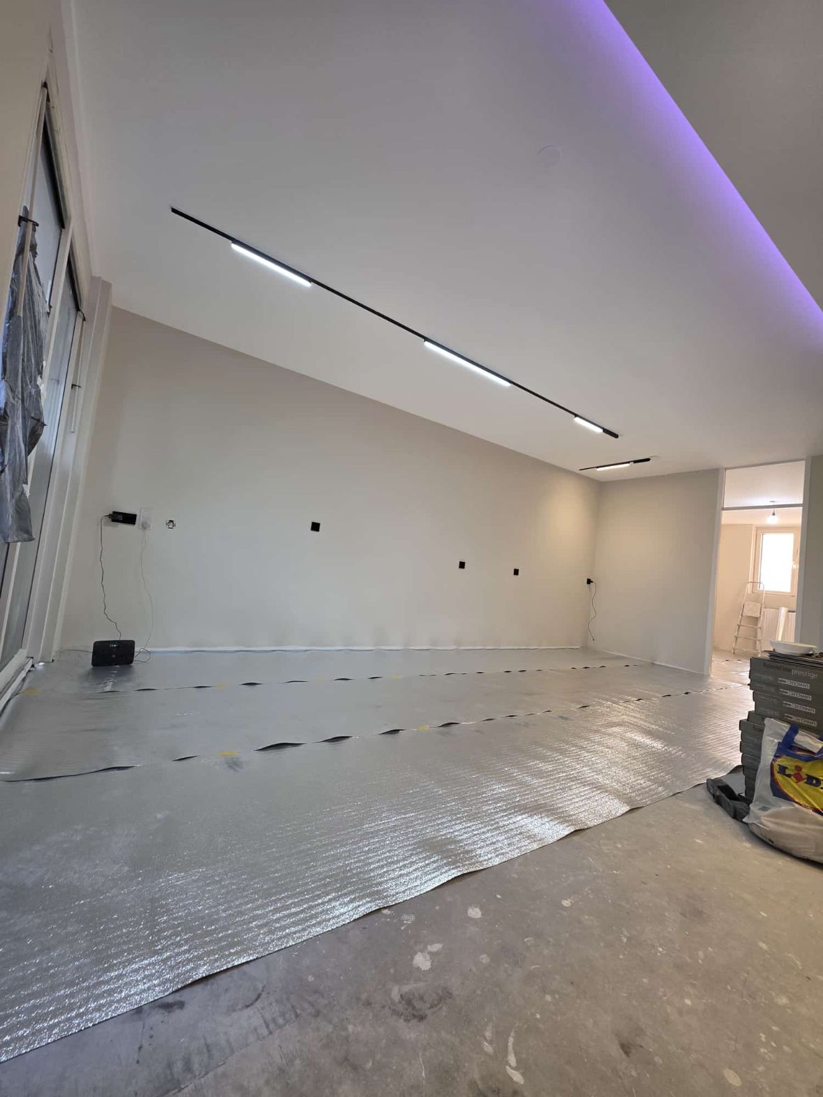 Renovatie woning Zaanstreek: Woonkamer afgewerkt, lichtlijn en indirecte verlichting geplaatst, ondervloer wordt gelegd