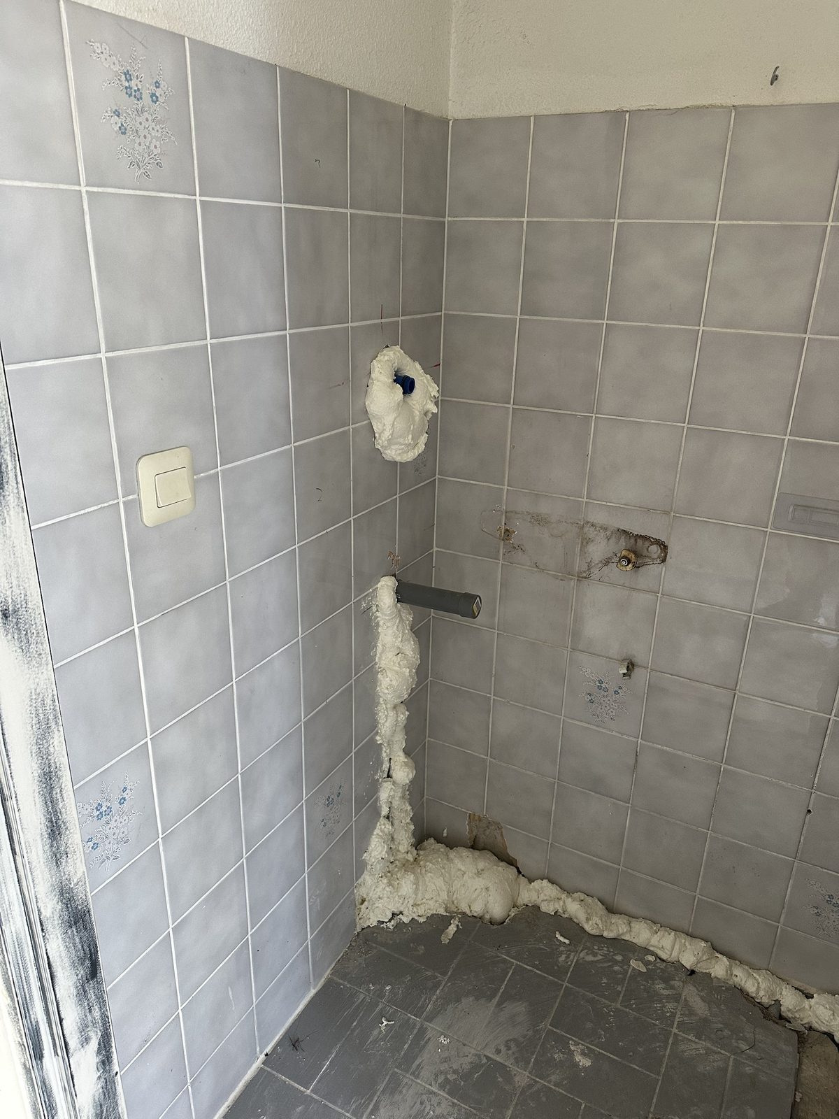 Voor: oude wandtegels en een losse afvoer